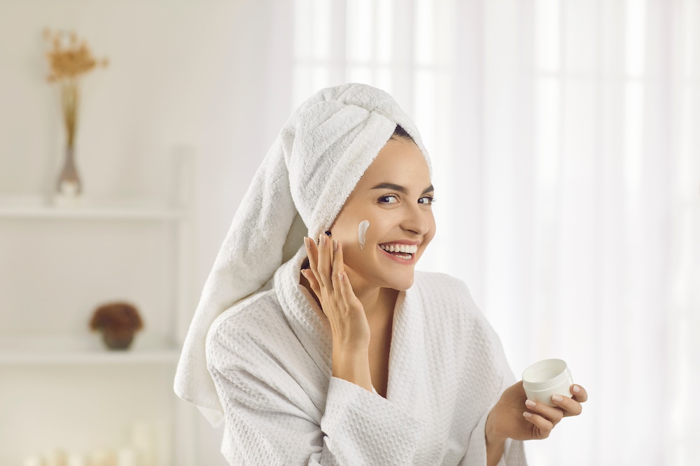 young woman using natural moisturising face cream